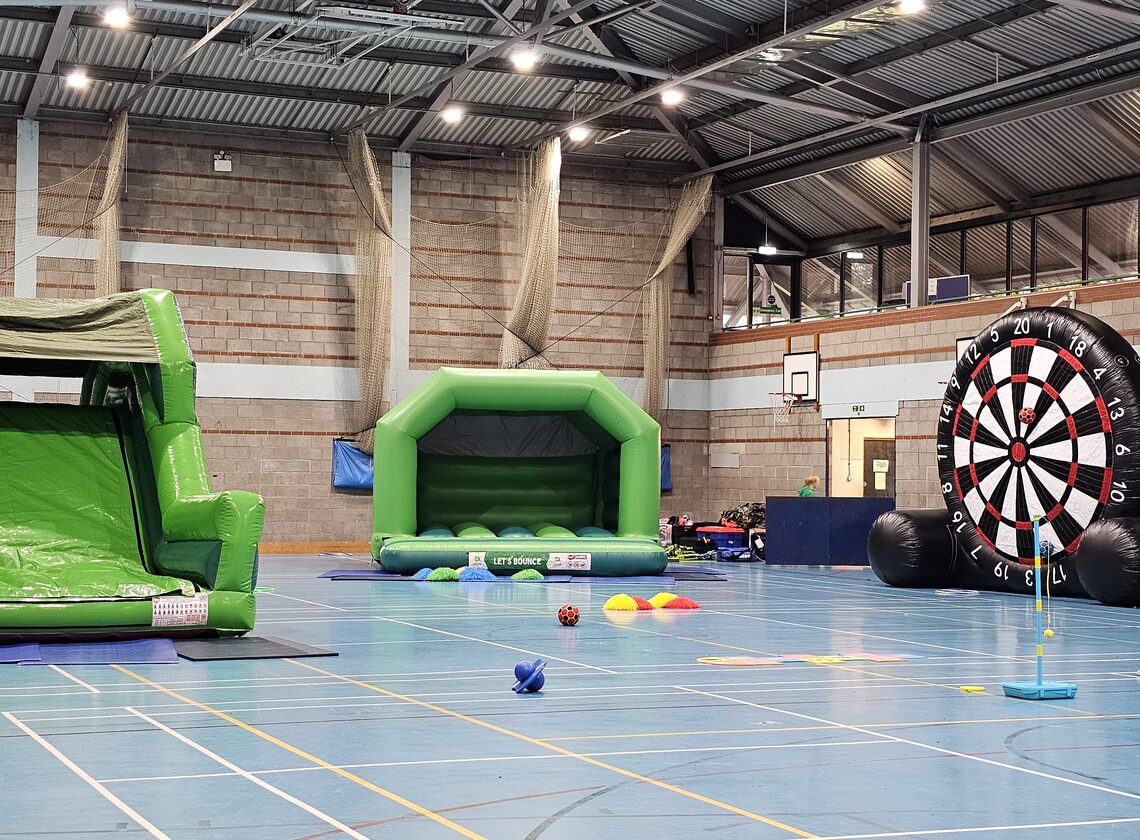 Inflatable slide, bouncy castle and football darts in the sports hall