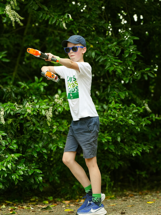 A child taking part in a NERF activity outdoors
