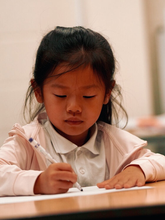 A child concentrating on a craft activity at uKids camp