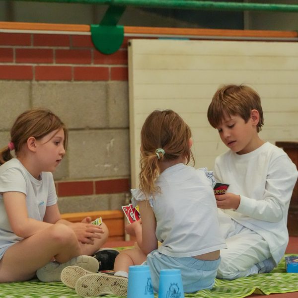 Children playing a card game together at uKids camp