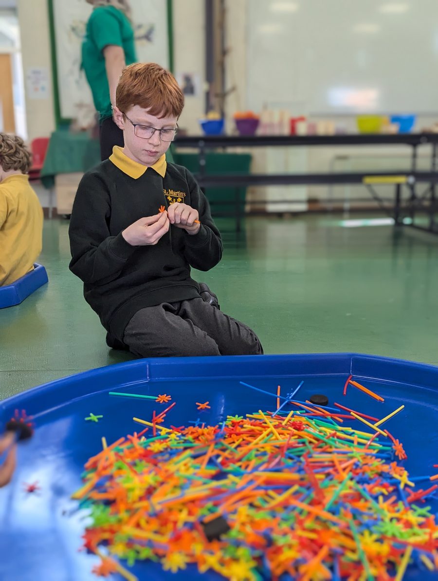 A child building with construction straws at uKids club at St Martin’s
